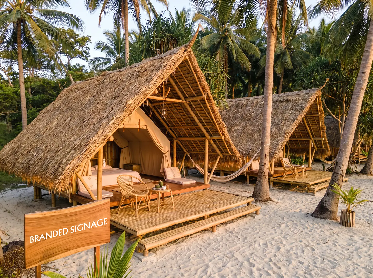 Beachfront glamping huts with A-frame thatch roofs on a Palawan sandbar
