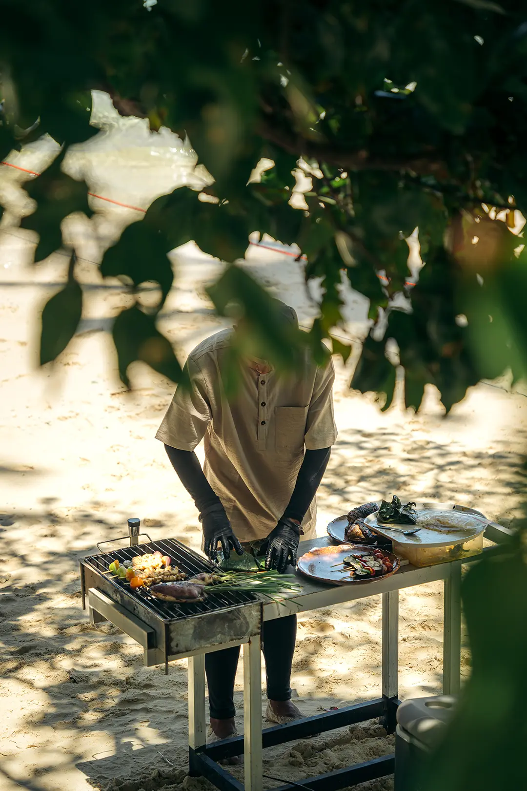 Private beach chef grilling seafood in El Nido